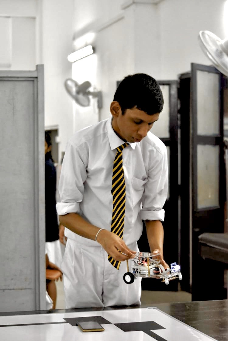 Student representing the clubs and societies of Royal College at a Robotics Competition